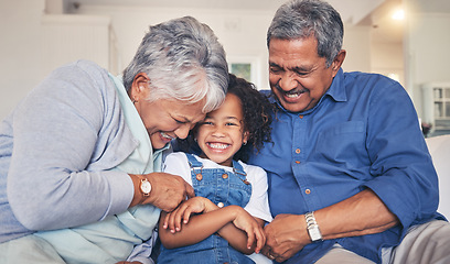 Image showing Grandparents tickling child, happiness and funny, relax at home at the weekend with retirement and love. Fun, playful and old people with young kid on sofa in living room, laughter and bonding