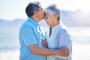 Image showing Kiss, love and senior couple at a beach for travel, bond and happy in nature together. Romance, kissing and elderly man embrace old woman at sea, trust or security on traveling ocean trip in Mexico
