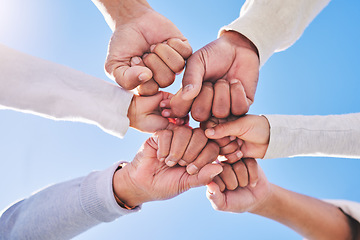 Image showing Hands in circle, blue sky and diversity for community in collaboration for global support and success. Teamwork, fist and bottom view of group of friends with positive vision, trust and love outdoors