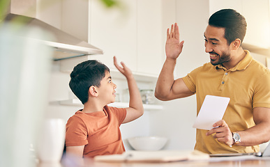 Image showing High five, homework and father with child at their home in celebration of completed studying. Happy, smile and young dad bonding together with his boy kid in the kitchen of modern house or apartment.