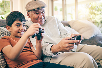 Image showing Family, fun and a boy gaming with his grandfather on a sofa in the living room of their home during a visit. Video game, children and a senior man learning how to play from his gamer grandson