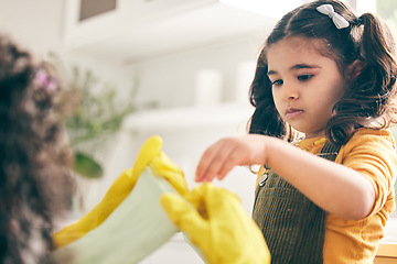 Image showing Girl, mom and kitchen to put rubber gloves on hands, helping and show skills in family home. Spring cleaning, mother and daughter by ppe, hygiene and teaching for safety, bacteria and dirt in house