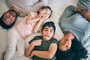 Image showing Top view, face and funny family in bed at home together, bonding to relax or having fun. Portrait, laughing and mother, father and children in bedroom, smile and happy for comedy in interracial house