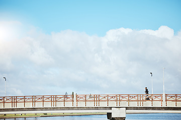 Image showing Fitness, sky and a man running on a bridge for a cardio or endurance workout on cloud mockup space. Exercise, sports and training for a marathon with a male runner or athlete outdoor for a challenge