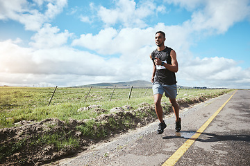 Image showing Fitness, marathon runner and man outdoor on road, cardio and healthy body. Athlete, training and exercise in race competition, workout energy or endurance sports on street at countryside in summer