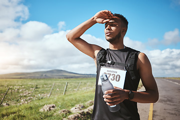 Image showing Fatigue, marathon runner and man with water outdoor on road, fitness and healthy body. Tired, bottle and exhausted athlete sweat in training, exercise and workout in race competition at countryside