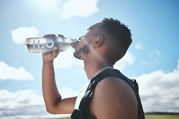 Image showing Runner, man and drinking water outdoor for fitness, healthy body and wellness in nutrition. Hydration, liquid bottle and athlete in training, exercise and marathon in race competition at countryside