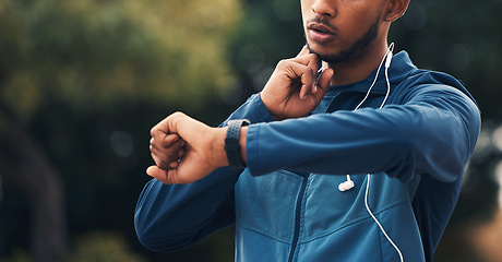 Image showing Hand, fitness and watch for pulse with a man runner outdoor in nature for cardio or endurance training. Exercise, time and heart rate with a young athlete in the forest to workout for health closeup