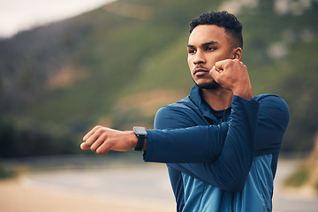 Image showing Runner man, stretching arms and mountain with thinking for fitness, health or wellness in street. Young guy, outdoor and start training in morning for marathon with idea, vision and warm up in nature