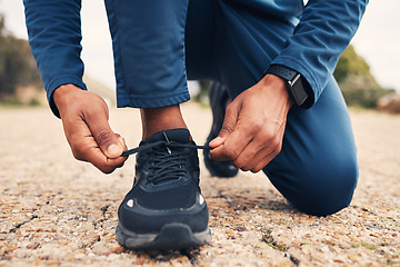 Image showing Tying laces, fitness and hands of a person for running, cardio or training preparation in nature. Closeup, ground and a runner or athlete with shoes and feet to start a race, marathon or a workout