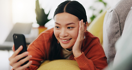 Image showing Asian woman, selfie and lying on sofa with hand on face and love for profile picture, vlog or social media at home. Happy female relaxing with smile and hand signs for photo or online vlogging on cou