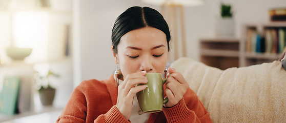 Image showing Thinking, coffee and Asian woman on couch, relax and decision with inspiration, decision and calm in living room. Japan, female and lady with tea, motivation and ideas in lounge, peace and gratitude