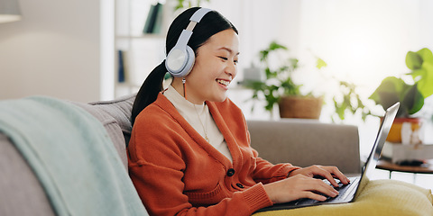 Image showing Laptop, headphones and asian woman on couch with work from home opportunity in online or website copywriting. Remote worker or person in china typing on her computer and listening to music at home