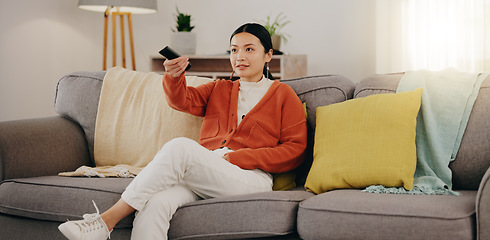 Image showing Watching tv, relax and an Asian woman on a sofa in the living room of her home streaming a subscription service. Television, channel surfing and comedy with an attractive young female sitting in her