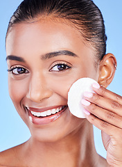 Image showing Happy woman, face and portrait with cotton pad for healthy skincare, cosmetics or aesthetic on blue background in studio. Indian model, facial cleaning and beauty of dermatology, shine or wipe makeup