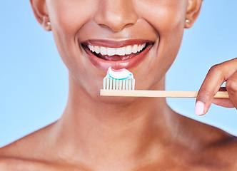 Image showing Closeup, mouth or woman brushing teeth in studio for dental care, fresh breath or healthy smile on blue background. Face of happy model, eco friendly bamboo toothbrush and toothpaste of oral cleaning