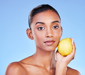 Image showing Lemon, portrait or natural skincare of woman in studio for vitamin c benefits, eco cosmetics or nutrition. Face of indian model, healthy beauty or citrus fruit of vegan dermatology on blue background