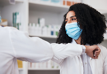 Image showing Elbow greeting, face mask and doctors at a pharmacy for a hello, conversation or medical communication. Morning, nursing and people in healthcare with a handshake for safety from virus at a clinic