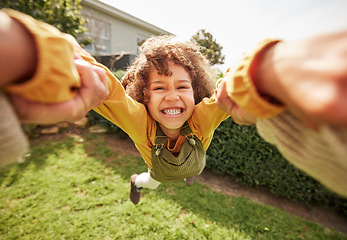 Image showing Kid, spin and outdoor in pov, holding hands and happy for game with parent, holiday or backyard. Excited young child, smile and swing in air, fast and grass for play on vacation, sunshine or portrait
