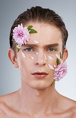 Image showing Head, cosmetics and flowers with portrait of man in studio for beauty, natural skincare and creative. Glow, serious and floral with face of model on white background for makeup, spa and wellness