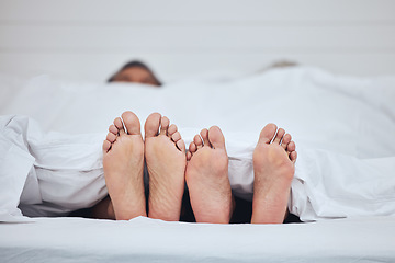 Image showing Couple, bed and feet with blanket in sleeping, peace and morning rest together on weekend at home. Barefoot people, asleep and comfort in bonding, care or love under duvet in bedroom at the house