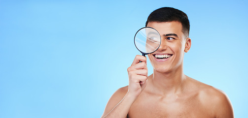Image showing Magnifying glass, skincare and man on blue background for wellness, healthy skin and mockup space. Dermatology, banner and face of person with lens for acne treatment, cosmetics and beauty in studio