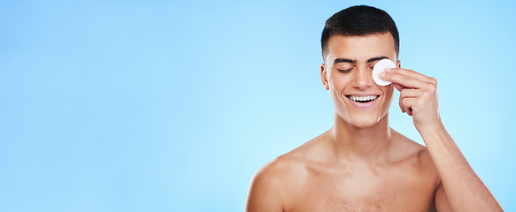Image showing Cotton pad, skincare and man on blue background for wellness, healthy skin and facial care. Dermatology banner, beauty mockup and person with patch for grooming, cosmetics and face hygiene in studio