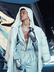 Image showing Fashion, future and cyberpunk with a model in a silver outfit for a magazine photo shoot in studio. Art, holographic and sci fi with a young man posing for creative, vaporwave or trendy style