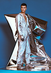 Image showing Holographic, vaporwave fashion and man with futuristic ski style with sci fi clothing in studio. Art, creative and male model with trendy, cool and cyberpunk designer clothes with blue background