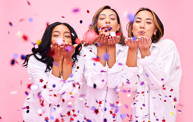 Image showing Blowing confetti, friends and women in studio for party celebration, fashion sale and discount. Bonding, diversity and happy people on pink background for support, natural beauty and retail promotion