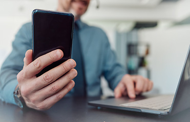 Image showing Businessman, hands and phone with laptop in communication, social media or networking at the office. Closeup of man working on computer and mobile smartphone technology in telemarketing at workplace