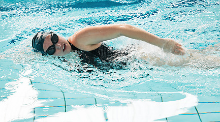 Image showing Woman, pool and swimming in water for exercise, sports fitness or training in athletic triathlon. Female person, athlete or professional swimmer in competition, race or marathon in workout practice