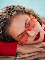 Image showing Face, summer and sunglasses with a hipster woman closeup in a swimming pool for safety or style. Fashion, thinking and poolside with a young swimmer looking bored waiting alone in trendy eyewear