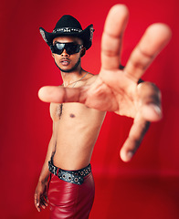 Image showing Man, portrait and fashion with grunge in studio or red background with unique cowboy aesthetic and sunglasses. Gen z, style and model with pride and hand in photography, retro or western clothing