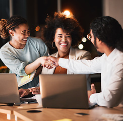 Image showing Night, handshake and business people in discussion in office with partnership, deal or collaboration. Laptop, team and professional designers shaking hands for working overtime on creative project.