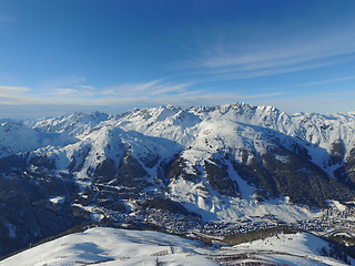 Image showing Mountains, snow and nature with landscape and village, travel and adventure with winter, Earth and scenery. Arctic, alps and mockup space, cold environment and land, hiking path and buildings