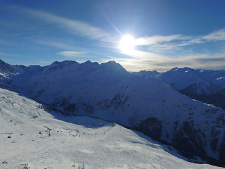 Image showing Mountain, snow and ski in the Swiss Alps for travel, holiday or vacation with a sun view of nature. Environment, landscape or adventure at a resort lift in the cold weather season of winter in Europe