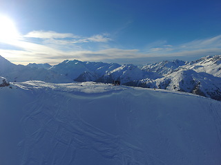 Image showing Mountains, snow and nature, people and ski with travel, adventure and winter, Earth and scenery. Arctic, alps and blue sky with ice, cold environment and snowy land with hiking path, cliff or hills