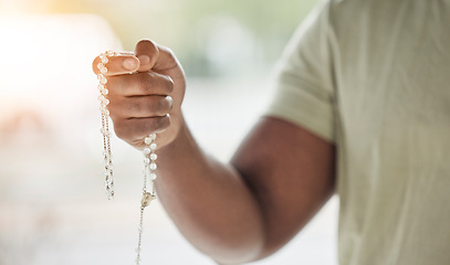 Image showing Rosary, man hand and faith with prayer beads in home with hope, christian praise and religion. Praying, necklace and worship in house with hope, gratitude and spiritual guide for support and healing