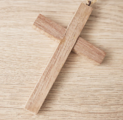 Image showing Background, religion and closeup of wooden cross on table for worship to God, prayer and resurrection of Jesus Christ. Faith, christianity and crucifix sign for holy spirit, heaven or spiritual trust