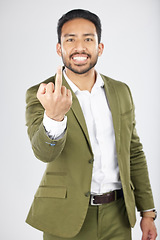 Image showing Business man, middle finger and studio portrait with anger, rude and frustrated by white background. Indian entrepreneur, smile and emoji for sign language, vote and opinion with hand for conflict