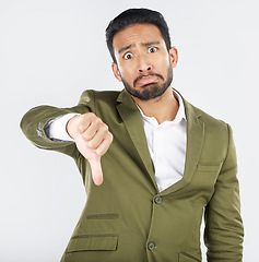 Image showing Portrait, frown and man with thumbs down in studio for rejection, no or bad review on white background. Face, sad and Japanese model with emoji hand for negative, vote or feedback fail and opinion