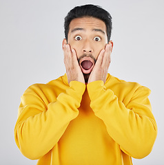 Image showing Wow, news and hands on face of man in studio for omg, surprise or promo on white background. Wtf, emoji and portrait of Japanese guy model shocked by announcement, gossip info or coming soon sale