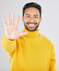 Image showing Man, palm and stop in studio portrait, smile and emoji for opinion, rejection or no by white background. Young Indian guy, student or fashion model with hand, sign language or show gesture for review