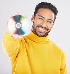 Image showing Man, cd and smile in studio portrait for music, tech or software for data, info or sound by white background. Student guy, happy model and retro disk storage or dvd for film, multimedia or movie