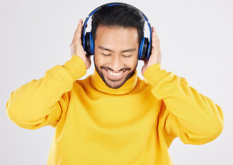 Image showing Man, headphones and listening with smile, studio and hearing with streaming subscription by white background. Young Mexican guy, student or fashion model with audio, music and sound with online radio
