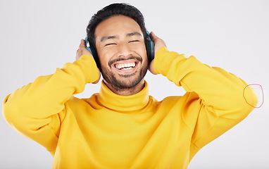 Image showing Man, headphones and excited for listening in studio, smile or hearing with streaming subscription by white background. Indian guy, student or fashion model with audio, music or happy for online radio