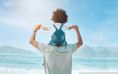 Image showing Back, piggyback and a man with his daughter on a beach, looking at the view together on holiday or vacation. Summer, freedom and family with a man carrying his girl child on his shoulders by the sea