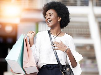 Image showing Black woman, shopping bag and happy customer walking outdoor in a city for retail deal, sale or promotion. African person with gift, smile and excited about buying fashion product on urban travel