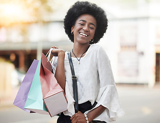 Image showing Black woman, shopping bag and portrait of a happy customer outdoor in a city for retail deal, sale or promotion. African person with a smile and excited about buying fashion product on urban travel